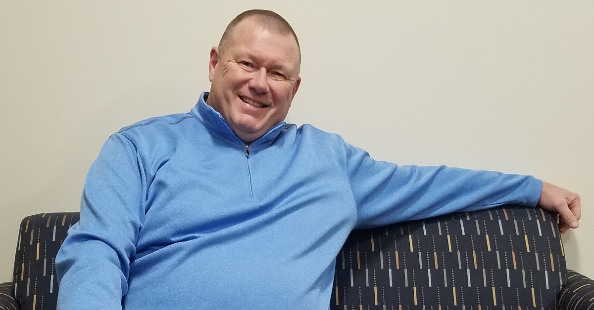 Dan Van Straten, smiling, sitting on a couch