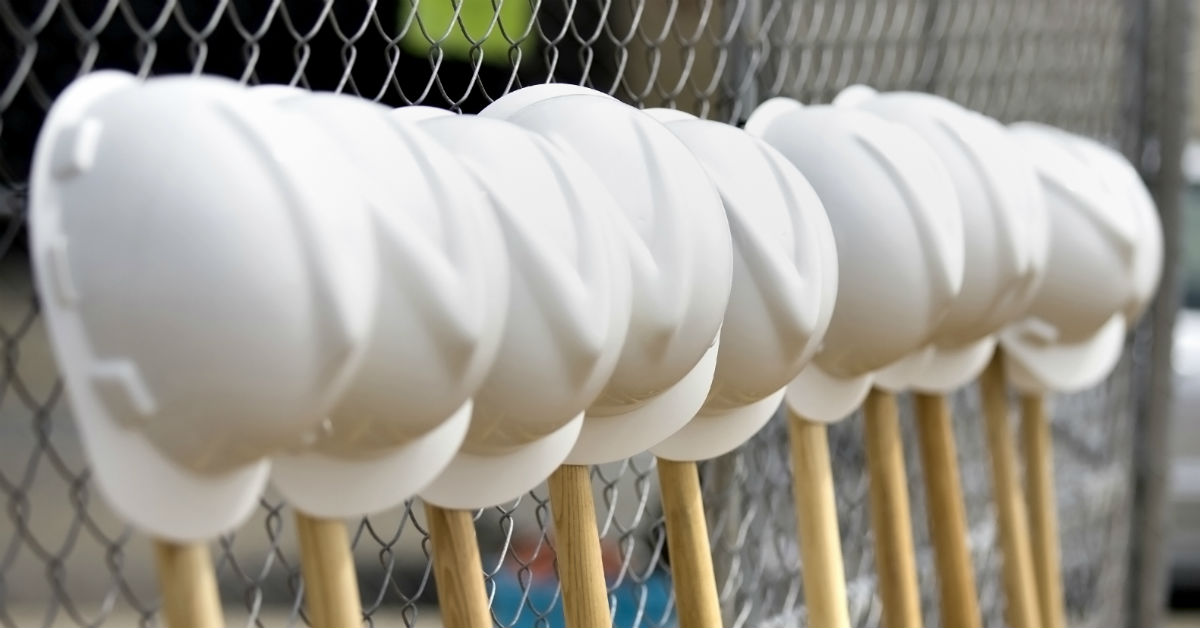 Row of shovels and construction helmets